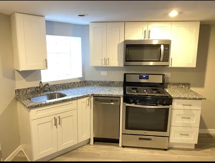 a kitchen with stainless steel appliances granite countertop a stove and a microwave