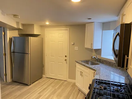 a kitchen with stainless steel appliances granite countertop a refrigerator and a sink