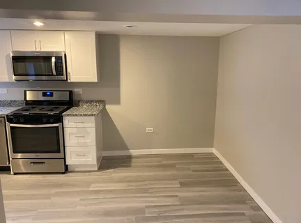 a view of a kitchen with wooden floor and electronic appliances
