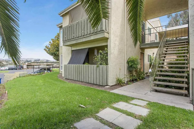 a view of a house with a small yard and wooden fence