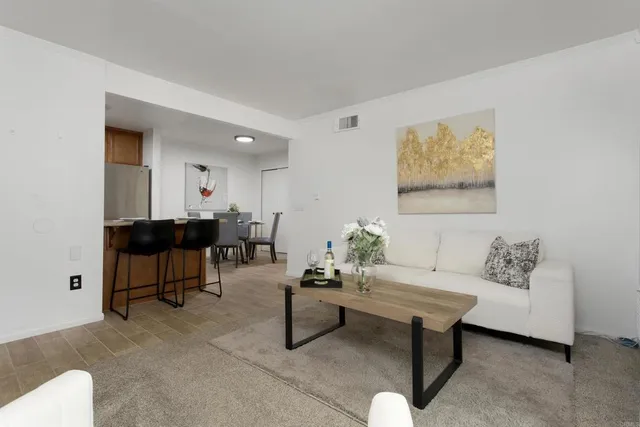 a living room with furniture and a painting on the wall