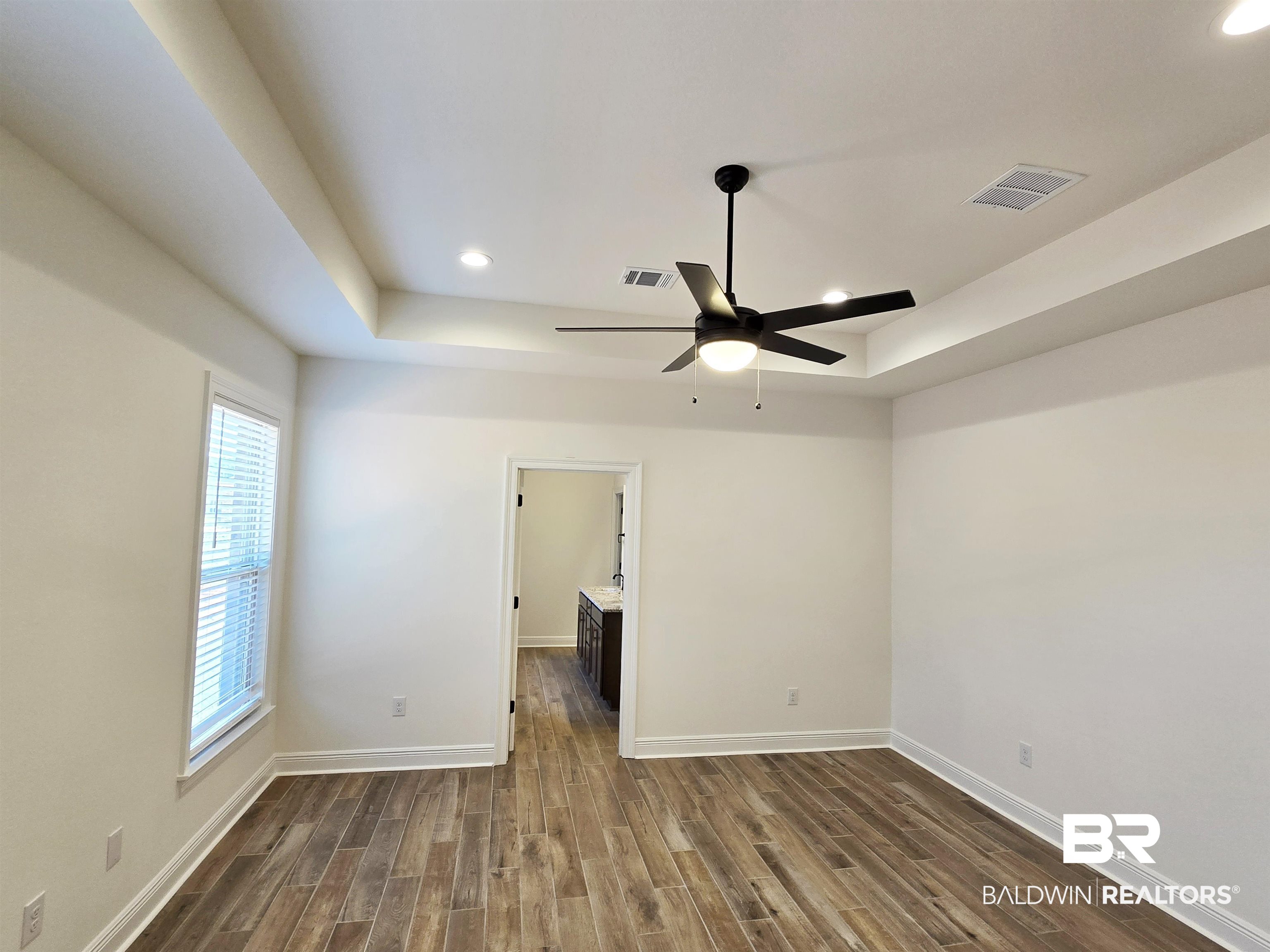 11178 Bonaventure Avenue Daphne, AL 36526 - Photo 10 of 20 Unfurnished bedroom with a raised ceiling, recessed lighting, wood finish floors, a ceiling fan, and connected bathroom