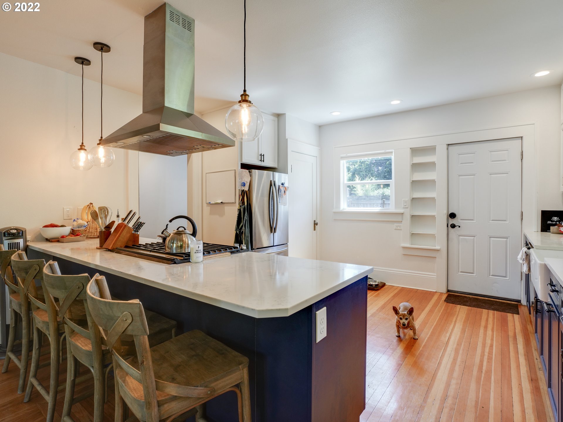 6676 North Mears Street Portland, OR 97203 - Photo 3 of 21 a kitchen with a sink dishwasher a dining table and chairs with wooden floor