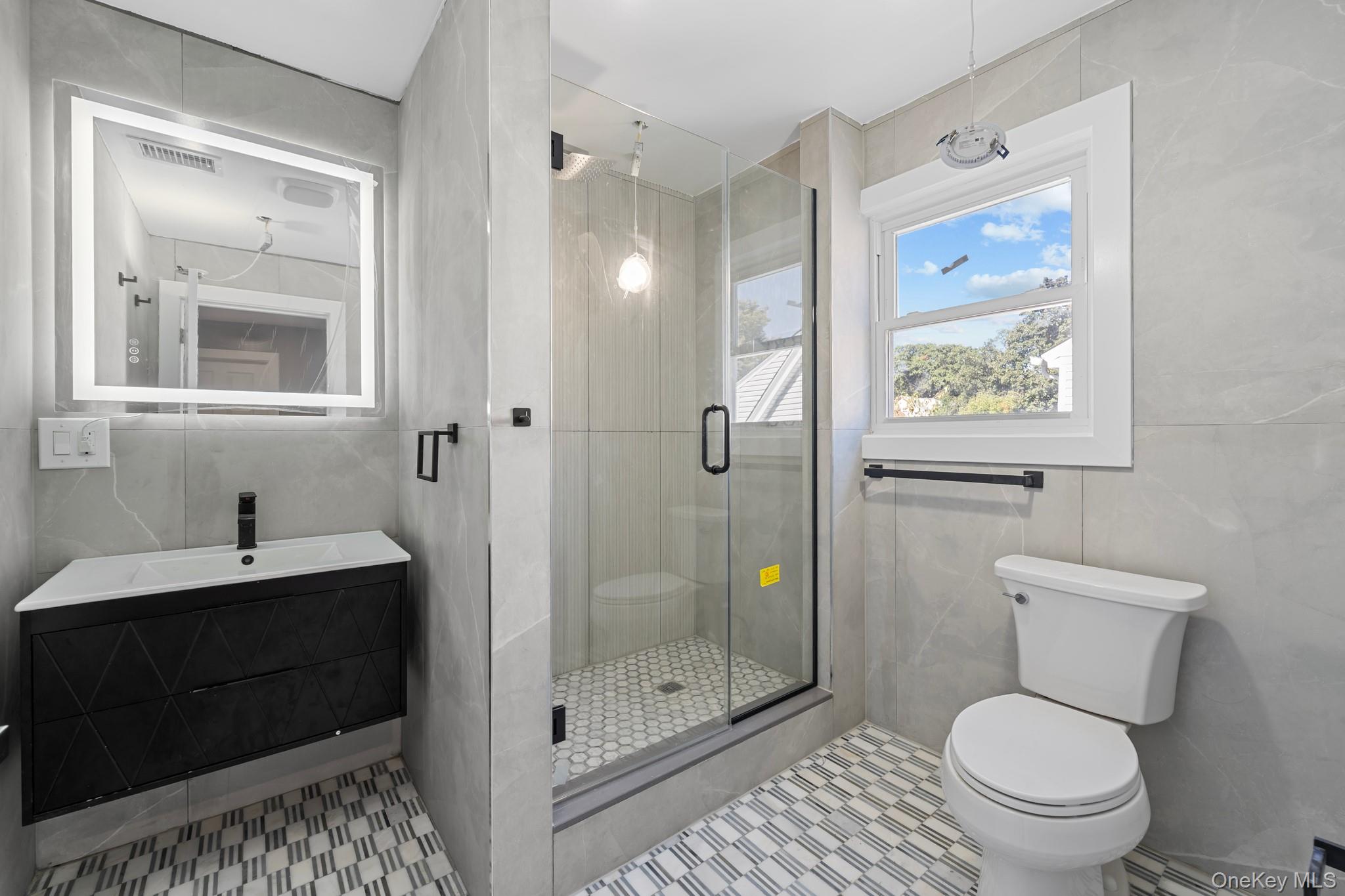 111-32 199th Street Queens, NY 11412 - Photo 11 of 19 Full bath with tile walls, a stall shower, and vanity