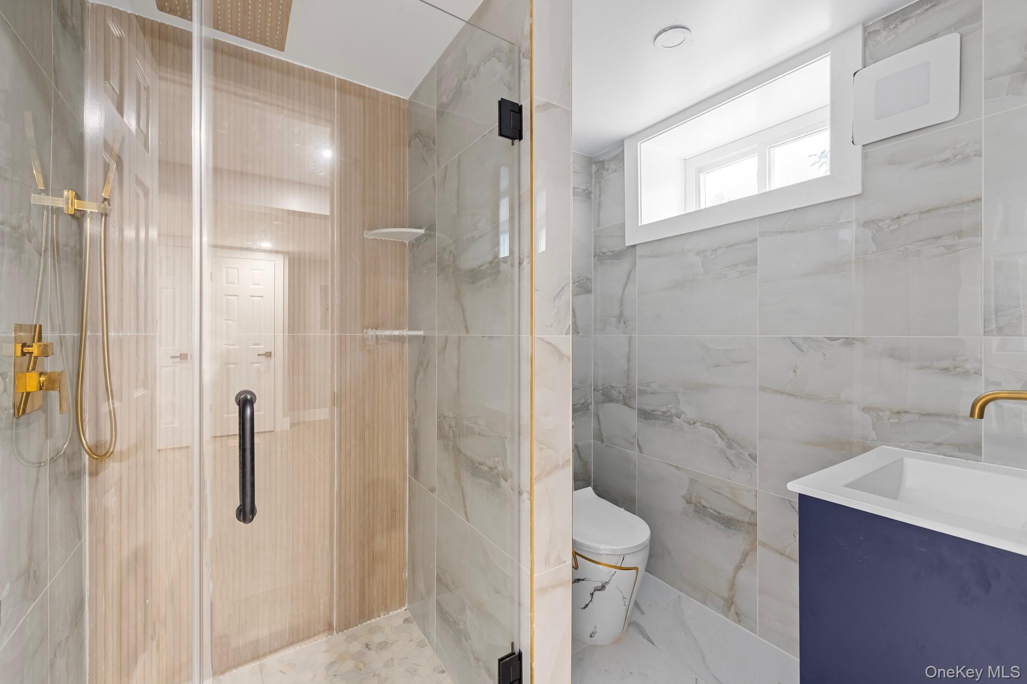 111-32 199th Street Queens, NY 11412 - Photo 15 of 19 Full bath featuring tile walls, vanity, and a marble finish shower