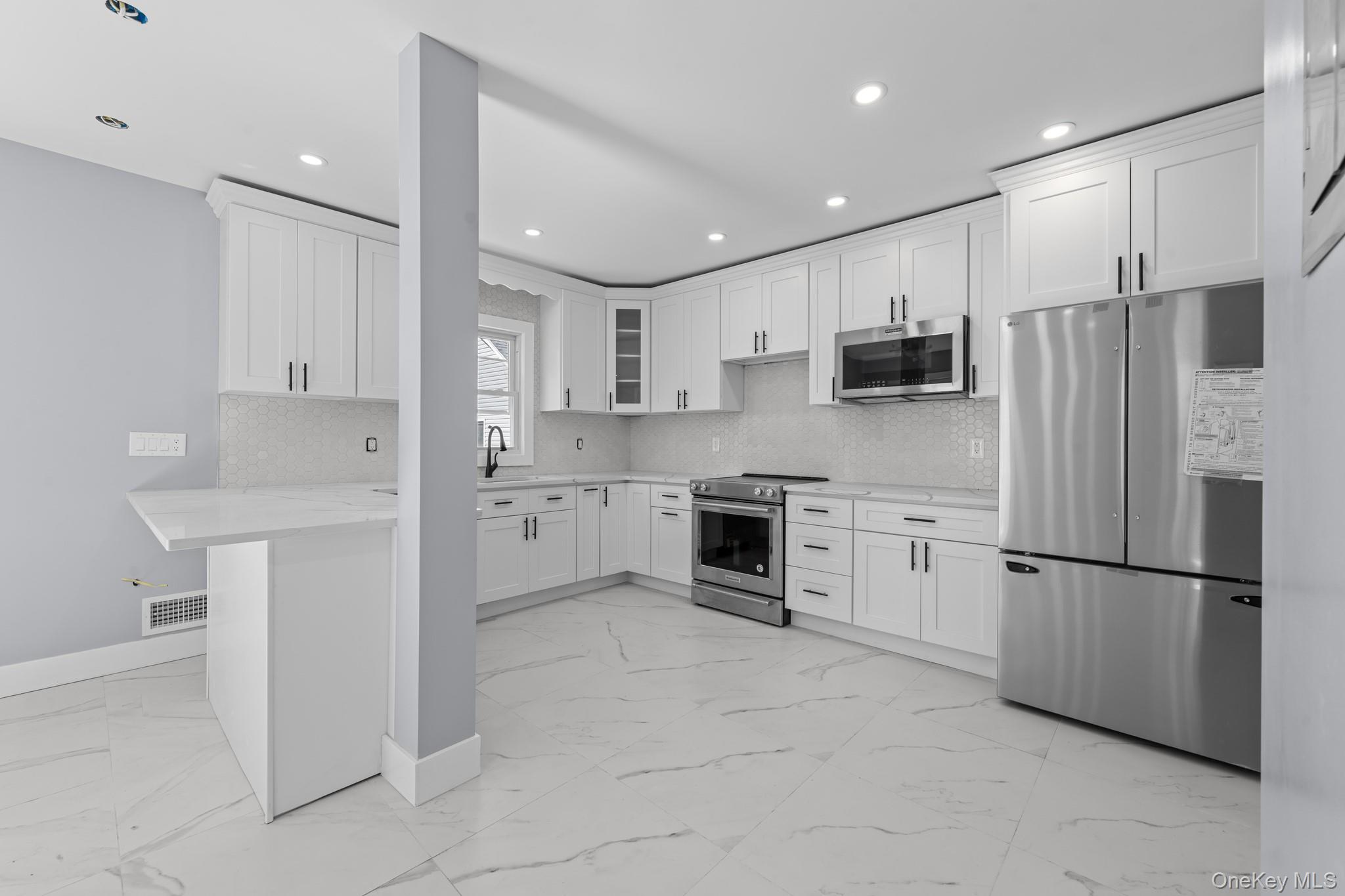 111-32 199th Street Queens, NY 11412 - Photo 2 of 19 Kitchen with stainless steel appliances, light marble finish floors, white cabinetry, glass insert cabinets, and recessed lighting