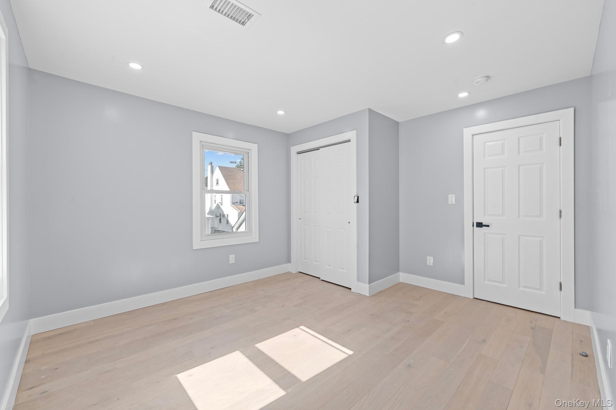 111-32 199th Street Queens, NY 11412 - Photo 10 of 19 Unfurnished bedroom with recessed lighting, light wood-style flooring, and a closet