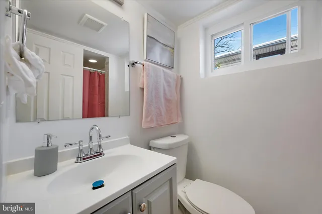 a bathroom with a toilet sink and mirror