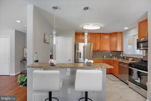 a large kitchen with granite countertop a sink and a refrigerator