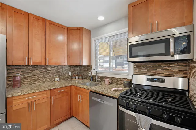 a kitchen with granite countertop cabinets stainless steel appliances and a sink