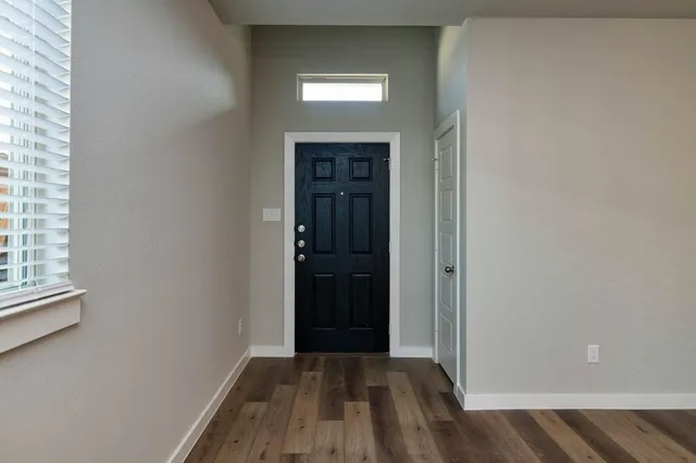 an empty room with wooden floor cabinet and closet