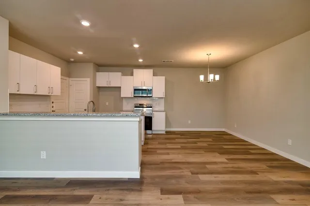 a large kitchen with kitchen island a sink stainless steel appliances and cabinets