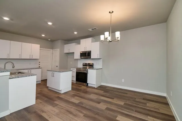 a kitchen with a refrigerator and white cabinets