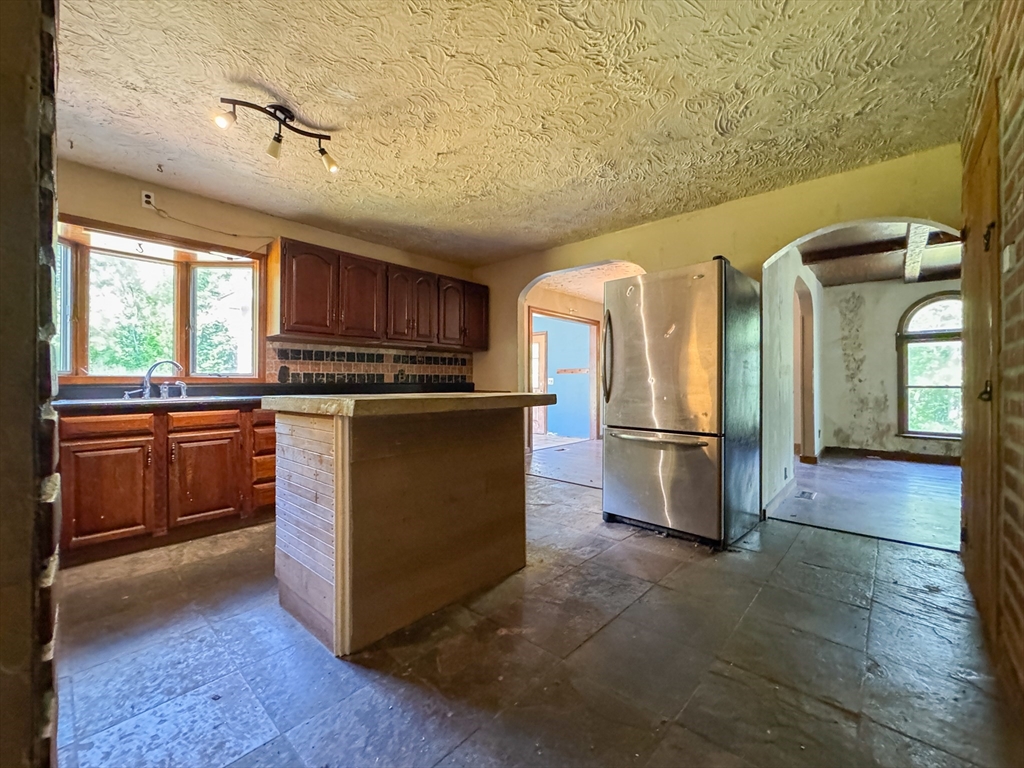 198 Union Road Wales, MA 01081 - Photo 20 of 42 a kitchen with stainless steel appliances granite countertop a stove a refrigerator and a sink with wooden cabinets