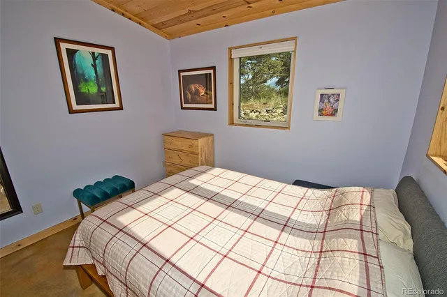 a bedroom with a bed and a painting on the wall