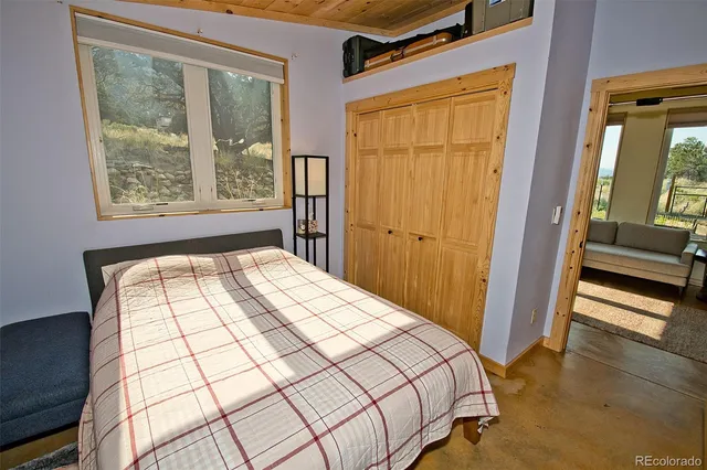 a bedroom with a bed and a large window