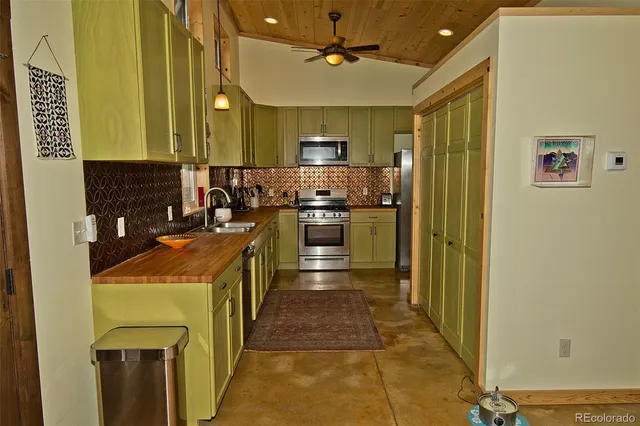 a kitchen with stainless steel appliances granite countertop a stove a sink and a refrigerator