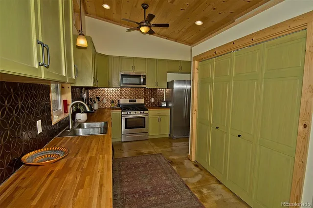 a kitchen with stainless steel appliances granite countertop a sink a stove and a refrigerator