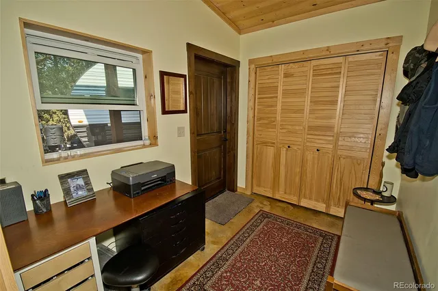 a view of a workspace with furniture and a window