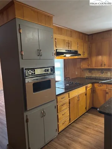 a kitchen with granite countertop a sink a stove and refrigerator