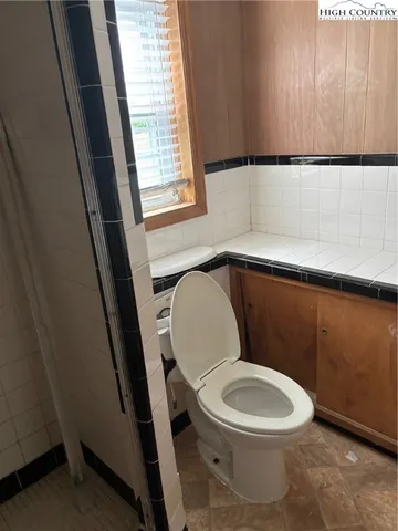 a white toilet sitting next to a window