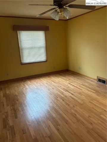 an empty room with a wooden floor and windows