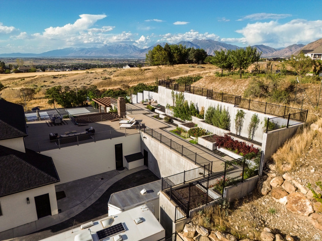 912 North Loafer Canyon Road Elk Ridge, UT 84651 - Photo 90 of 98 Multi-level concrete retaining walls with integrated planters, expansive upper-level patio, mountains in the distance, and established trees