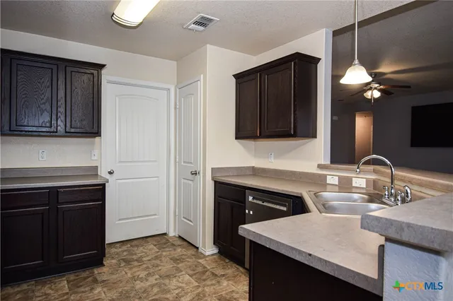 a kitchen with a sink cabinets and wooden floor