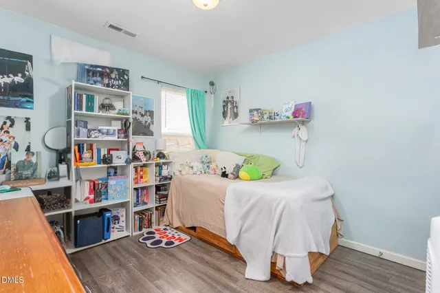 a bedroom with a bed and wooden floor