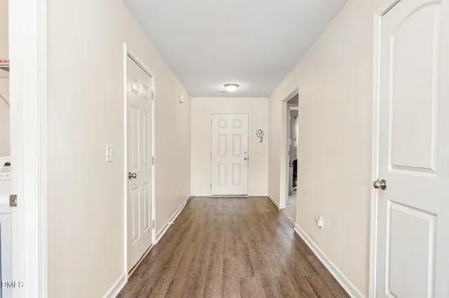 a view of a hallway with wooden floor