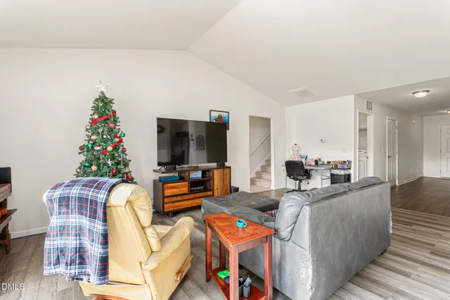 a living room with furniture a flat screen tv and a potted plant