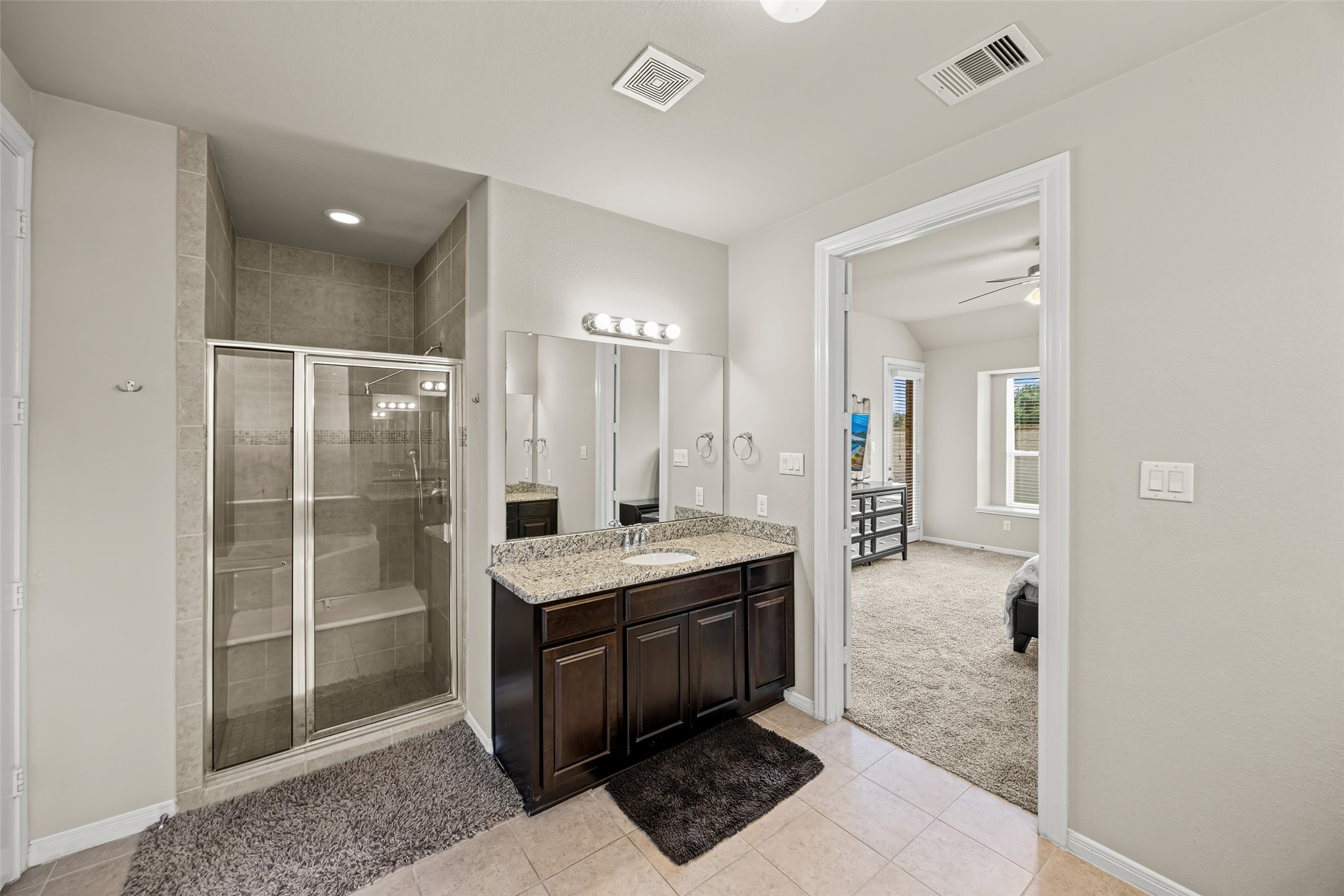 4438 Selwyn Road Richmond, TX 77407 - Photo 18 of 23 a spacious bathroom with a granite countertop sink a mirror and shower