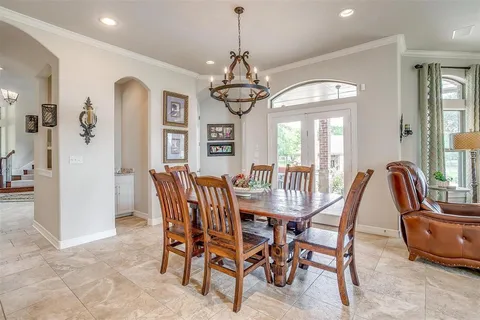 a dining room with furniture a chandelier and window