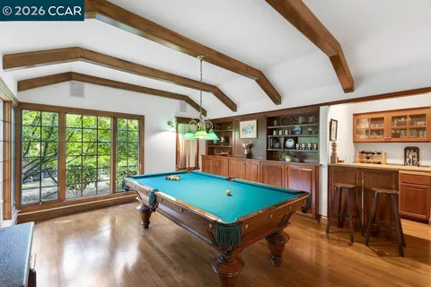 a room with pool table and windows