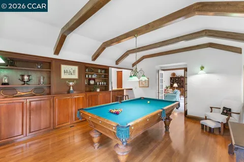 a room with pool table and wooden floor
