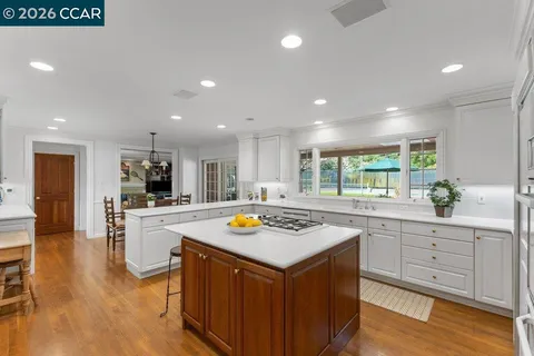 a kitchen with counter top space sink stove and wooden floor