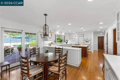 a kitchen with a dining table chairs stove and kitchen view