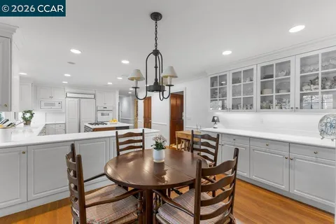 a kitchen with a table chairs sink and cabinets