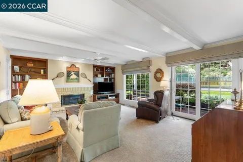 a living room with furniture a large window and a flat screen tv