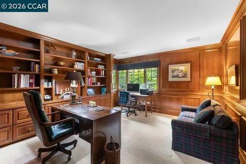 a living room with furniture a bookshelf and a window