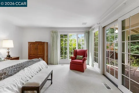 a bedroom with furniture and a large window