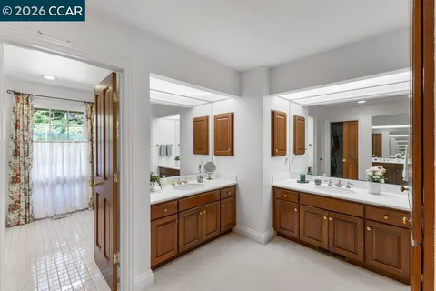 a spacious bathroom with a double vanity sink a large mirror and a shower