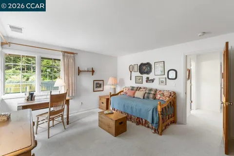 a bedroom with a bed and a large window