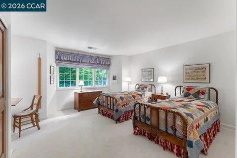a bedroom with two beds and a large window