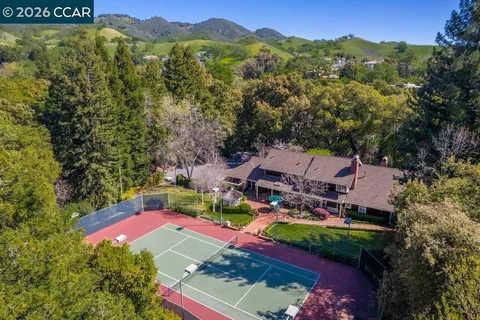 an aerial view of residential houses with outdoor space and trees