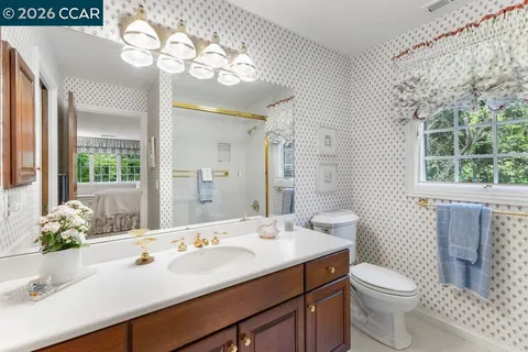 a bathroom with a sink a toilet and a large mirror