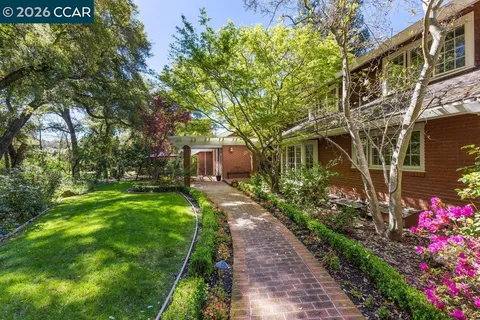 a front view of a house with a yard and fountain