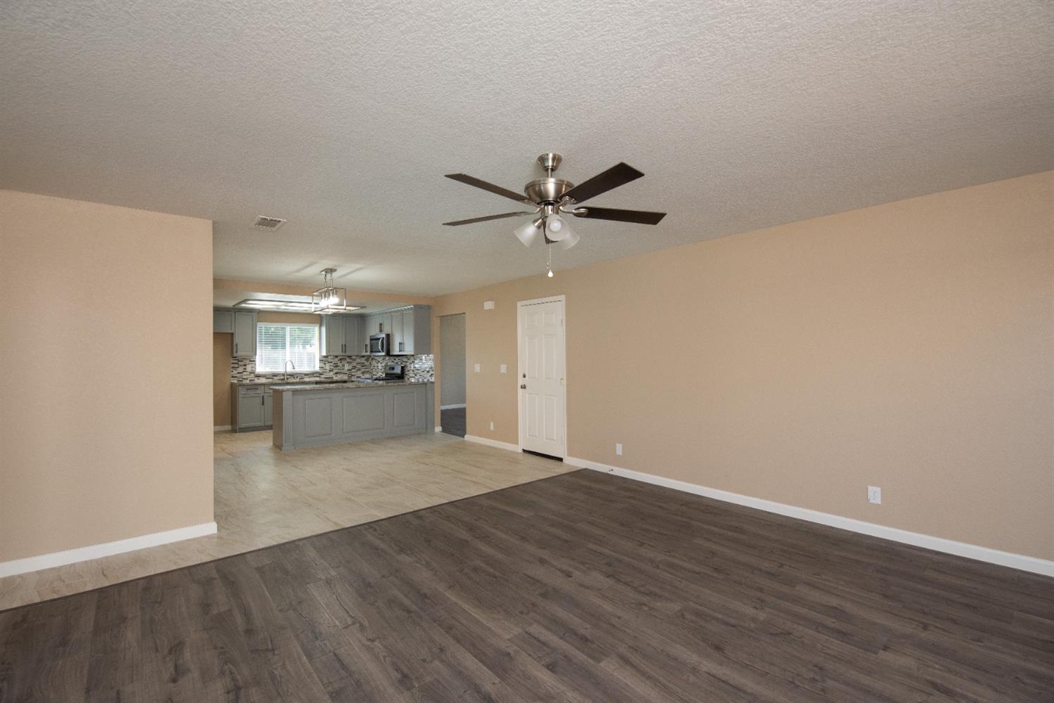1621 Davis Street Ripon, CA 95366 - Photo 20 of 43 unfurnished living room with dark wood-type flooring, a textured ceiling, and a ceiling fan
