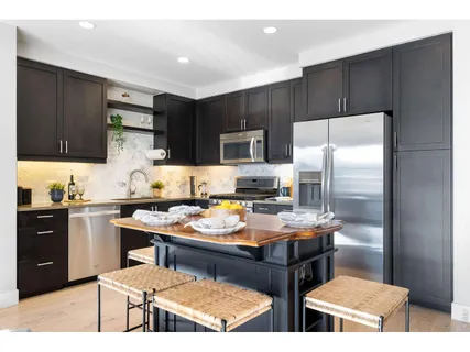 a kitchen with a refrigerator and a stove top oven