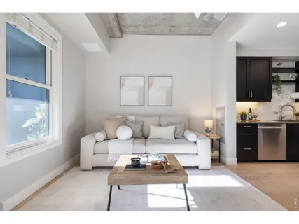 a living room with furniture a flat screen tv and kitchen view